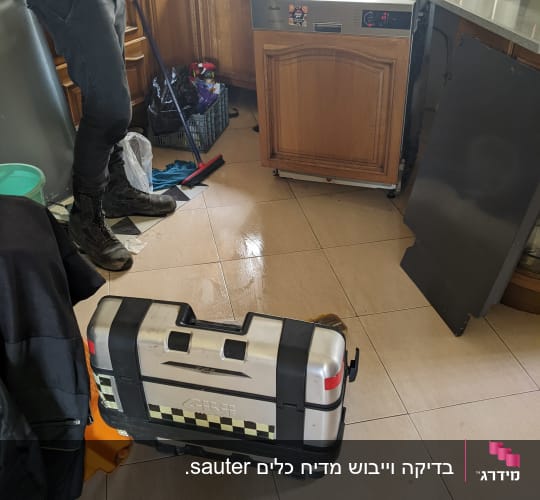 תיקון מדיח כלים במטבח עם כלי עבודה על הרצפה